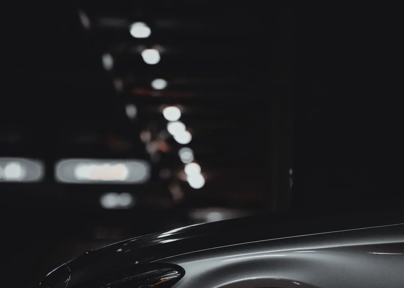The front of a car in a dimly lit workshop