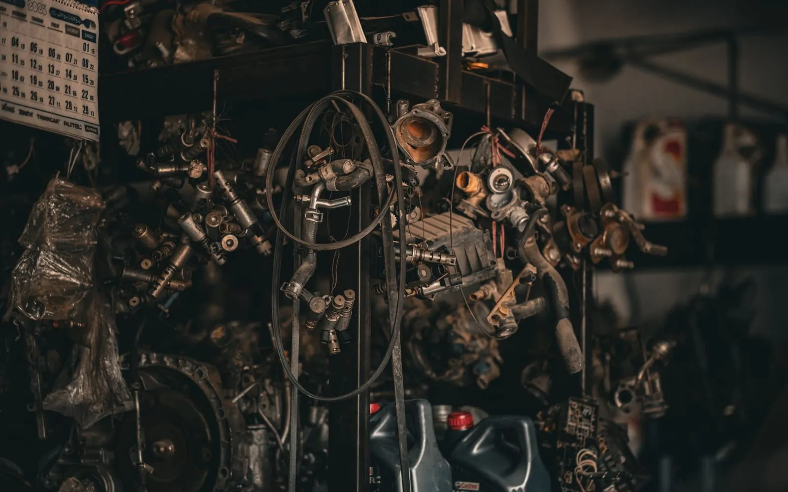 A dimly lit workshop, its shelves and benches crowded with mechanical parts